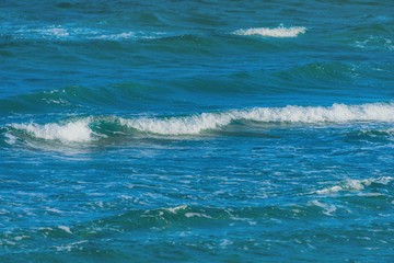 Abstract clean sea background, view on ripple foam surface of water. Deep turquoise blue ocean waves. Calm ocean water background landscape. Clear water wave texture. Marine aqua at tropical summer.