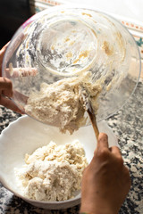 Woman preparing dough to cook homemade donuts at home. Kneading mixture to make a sweet and delicious dessert.