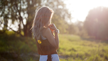 Obraz premium Cute charming girl in summer in the field. Young woman is happy and feels free outdoors.
