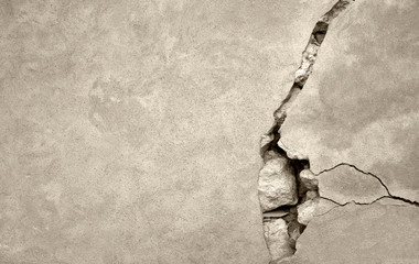 Big crack on the gray wall, abstract image of the vertical crack. Sepia toned. Selective focus. Copy space.
