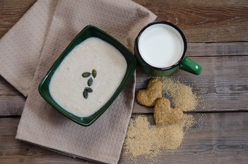 Healthy breakfast . Sesame dry cookies in the shape of heart, porridge of amaranth and yogurt on old wooden table