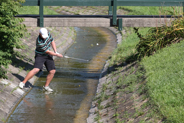 A tournament golfer hit a shot from a small creek, avoiding a penalty shot