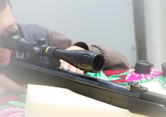 Close-up of a young man shooting. Sniper air rifle training