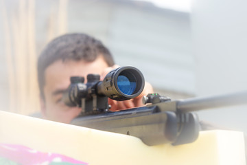 Close-up of a young man shooting. Sniper air rifle training