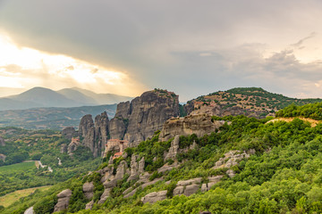 Fototapeta na wymiar Wonderful view of the rocks and monasteries of Meteora, Greece. Mysterious Sunny evening with colorful sky, during sunset. Awesome Nature Landscape. Amazing Greece. Popular travel locations