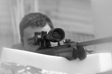 Close-up of a young man shooting. Sniper air rifle training