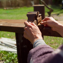 Female hands adjusting  rusty vice