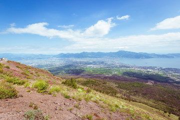 View from Vesuvius volcano in Italy to the coast of sea and city from above, against the sky.