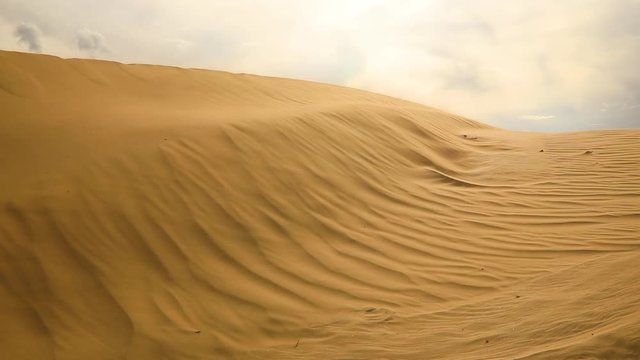 Strong wind in the desert. Sand blows from the dunes