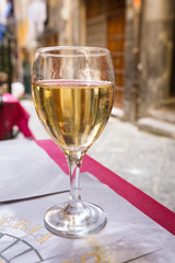Wine Glass of white wine on the table in a restaurant outside over blurred background