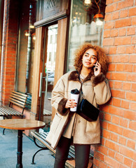 Fototapeta premium young pretty african american women drinking coffee outside in cafe, modern business woman lifestyle concept