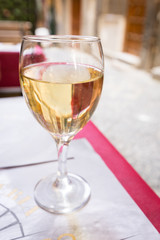Wine Glass of white wine on the table in a restaurant outside over blurred background