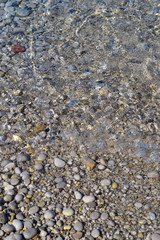 Sea stones in the sea water. Pebbles under water. The view from the top. Nautical background. Clean sea water. Transparent sea.