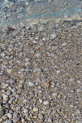 Sea stones in the sea water. Pebbles under water. The view from the top. Nautical background. Clean sea water. Transparent sea.