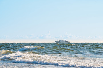 the ship sails on rough seas near the shore