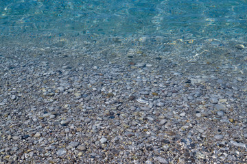 Pebbles under water. Marine background. Pure sea water. Clear sea