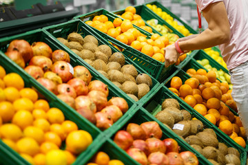 Fruits in the green plastic boxes on the grocery shelf