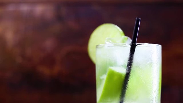 Typical drink from Brazil called Caipirinha, made with lemon and sugar with cacha&ccedil;a. Favorite cocktail of Brazil, isolated over wood texture.