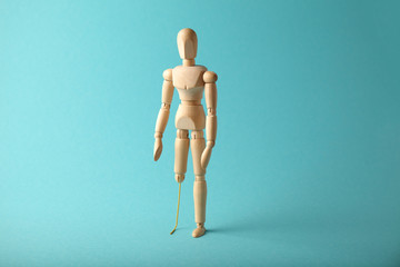 Wooden figure of man with artificial prosthetic leg. Amputee and disability concept.