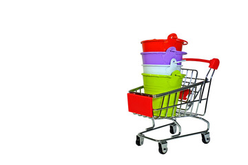 Red, purple, white and light green buckets staked in mini shopping cart isolate on white background on right of the frame.