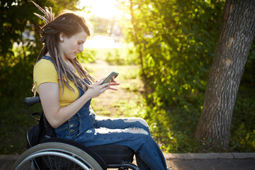 cheerful fashion girl spending time with her mobile phone, surfing the net, browsing the net, reading funny stories. close up side view photo.