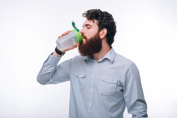 Photo of man in casual drinking protein after gym