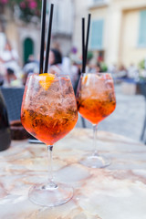 Glass of Aperol Spritz cocktail on the table in restaurant, famous refreshing drink, Italy.