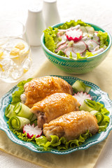 Stuffed chicken roasted thighs with vegetable garnish and herbs.