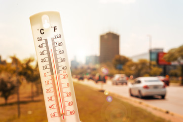 Thermometer in front of an urban scene during heatwave