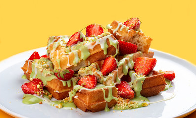 Belgian waffles with pistachio cream topping and strawberries