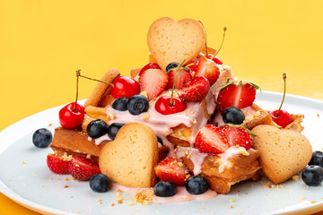 Belgian waffles with topping, cherries, strawberries and berries.