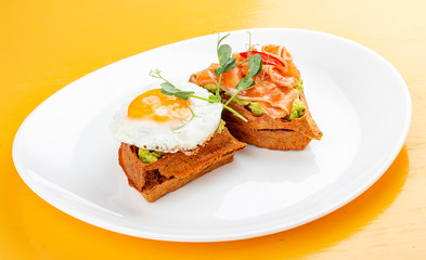 American waffle with salmon and egg, with avocado mousse. Healthy breakfast.