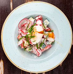 Vegetable salad of radish, cucumber and tomato with poached egg.