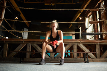 Obraz na płótnie Canvas Full length portrait of strong young woman waiting by boxing ring at sports club, copy space