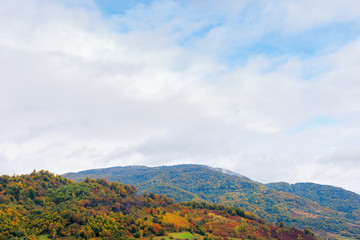 beautiful countryside on a rainy day in mountains. forested hills in fall foliage. overcast sky above the ridge. haze and mist in the valley. rural area of carpathians, uzhok, ukraine