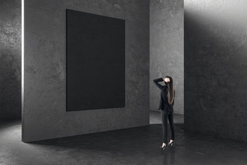 Businesswoman in interior with empty poster