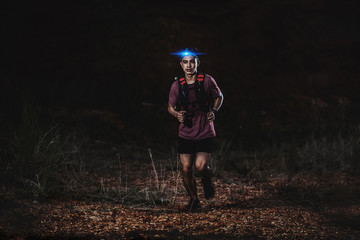 trail runner running on the rocky road in the night