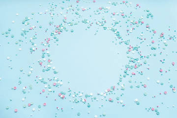 Festive abstract background for the design. Colorful confetti on a blue background. Top view, flat lay composition. Copy space for text.