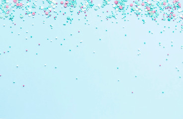 Naklejka na ściany i meble Festive abstract background for the design. Colorful confetti on a blue background. Top view, flat lay composition. Copy space for text.