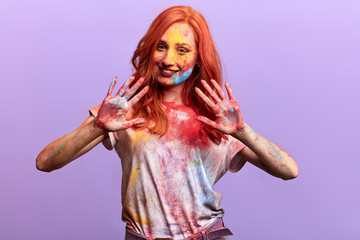 funny girl showing her dirty palms, close up portrait. isolated violet background, studio shot