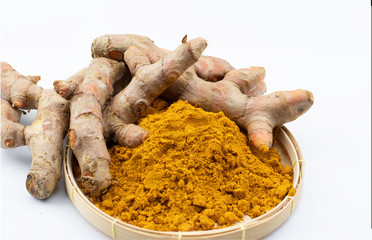 isolated turmeric root rhizome and turmeric powder on rattan basket on white background