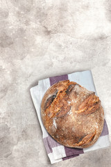 Loaf of freshly baked homemade organic sourdough bread over light background top view