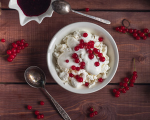 Light breakfast of cottage cheese with sour cream and red currant berries