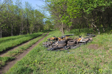 A pile of garbage auto parts in the forest.