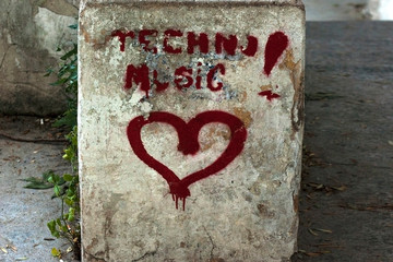 Red inscription on the old wall. I love techno music.