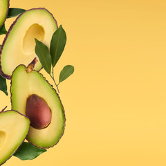 Fresh ripe avocado with leaves falling in the air.