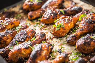 Grilled hicken legs BBQ with spices herbs and sesame on baked paper. Roasted poultry meal in roaster dish