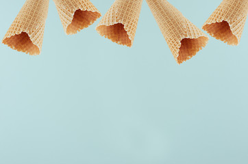 Empty waffle ice cream cones as decorative frame on  green background, mock up for advertising,...