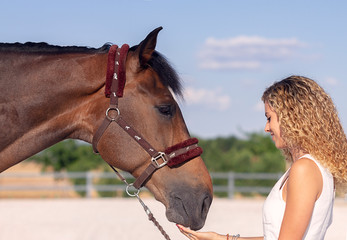 blonde girl stroking a horse