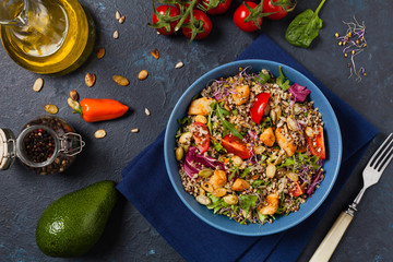 Salad with quinoa, avocado and chicken. Top view. Served in a blue bowl.